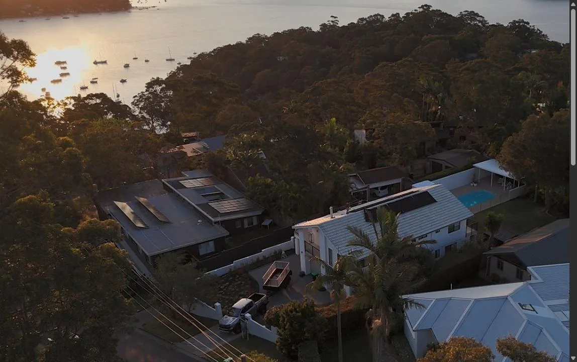 Drone shot over Panda Power solar installs by the bay at sunset