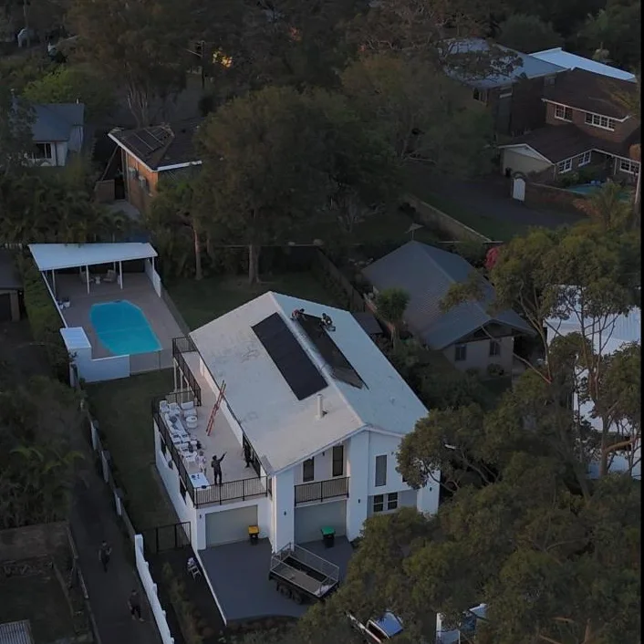 Drone view of the crew finishing a rooftop install beside the pool