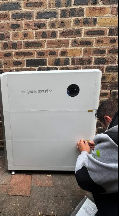 Technician commissioning a Sigenergy battery