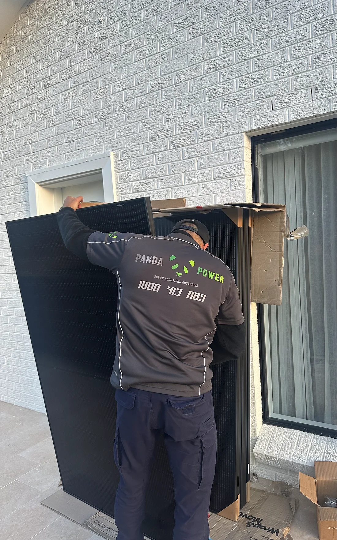 Panda Power installer carrying a solar panel on site
