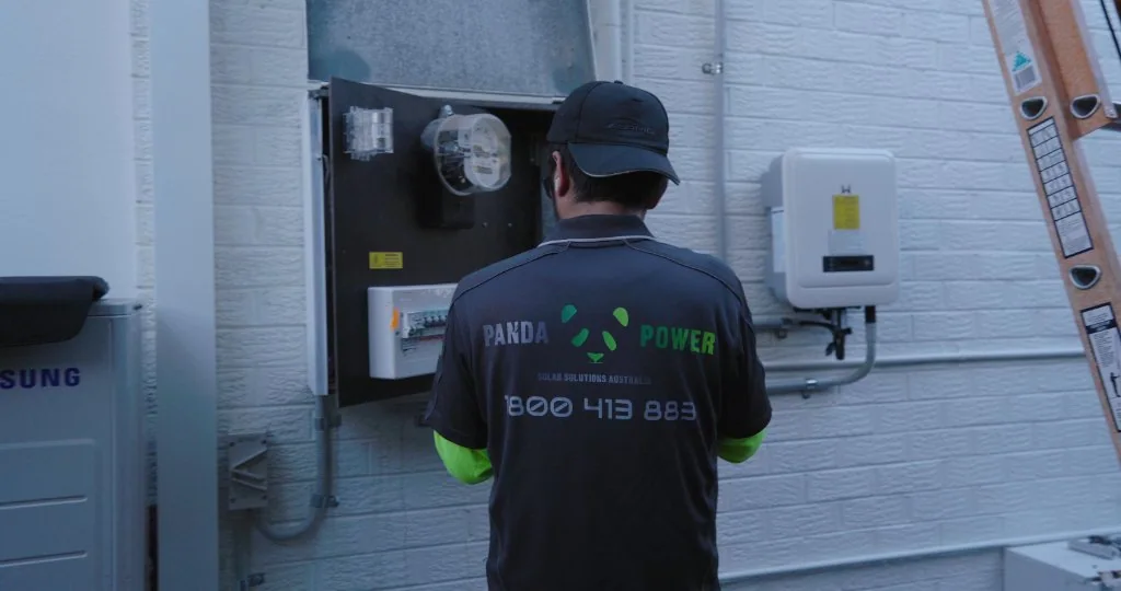 Technician installing a solar inverter