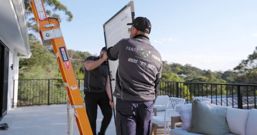 Two Panda Power team members installing solar panels