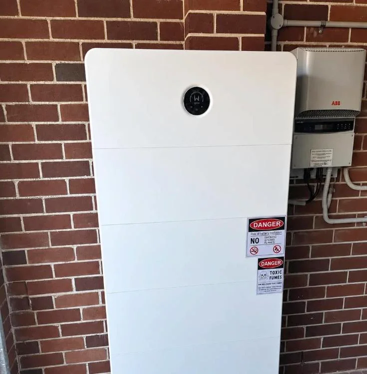 Home battery and inverter installed on a brick wall